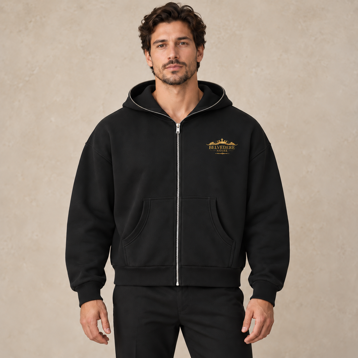 Model wearing the black Fleeced Full-Zip Boxy Hoodie with gold chest logo