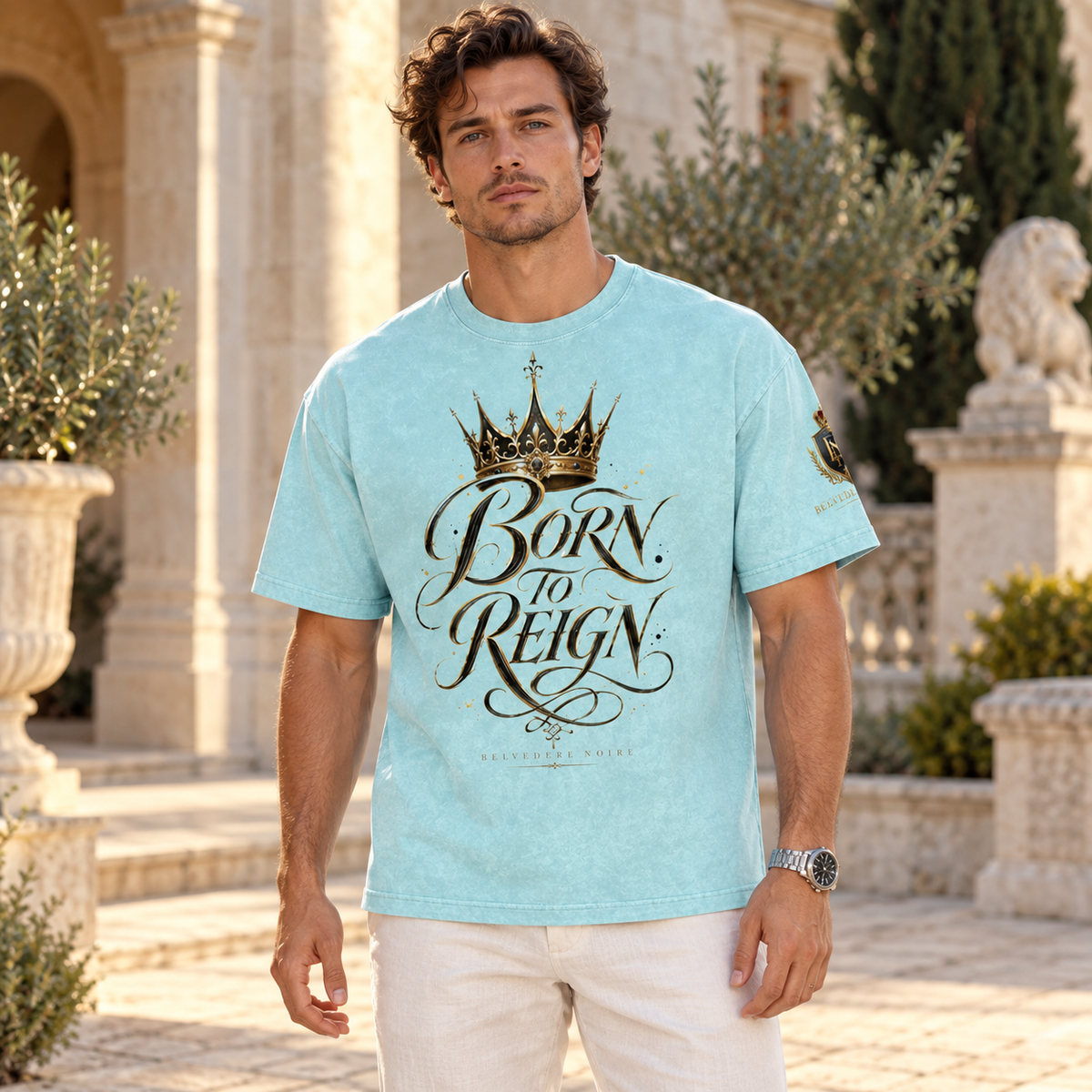 BELVEDERE NOIRE aqua Born to Reign tee, male model in courtyard, AI styling mockup