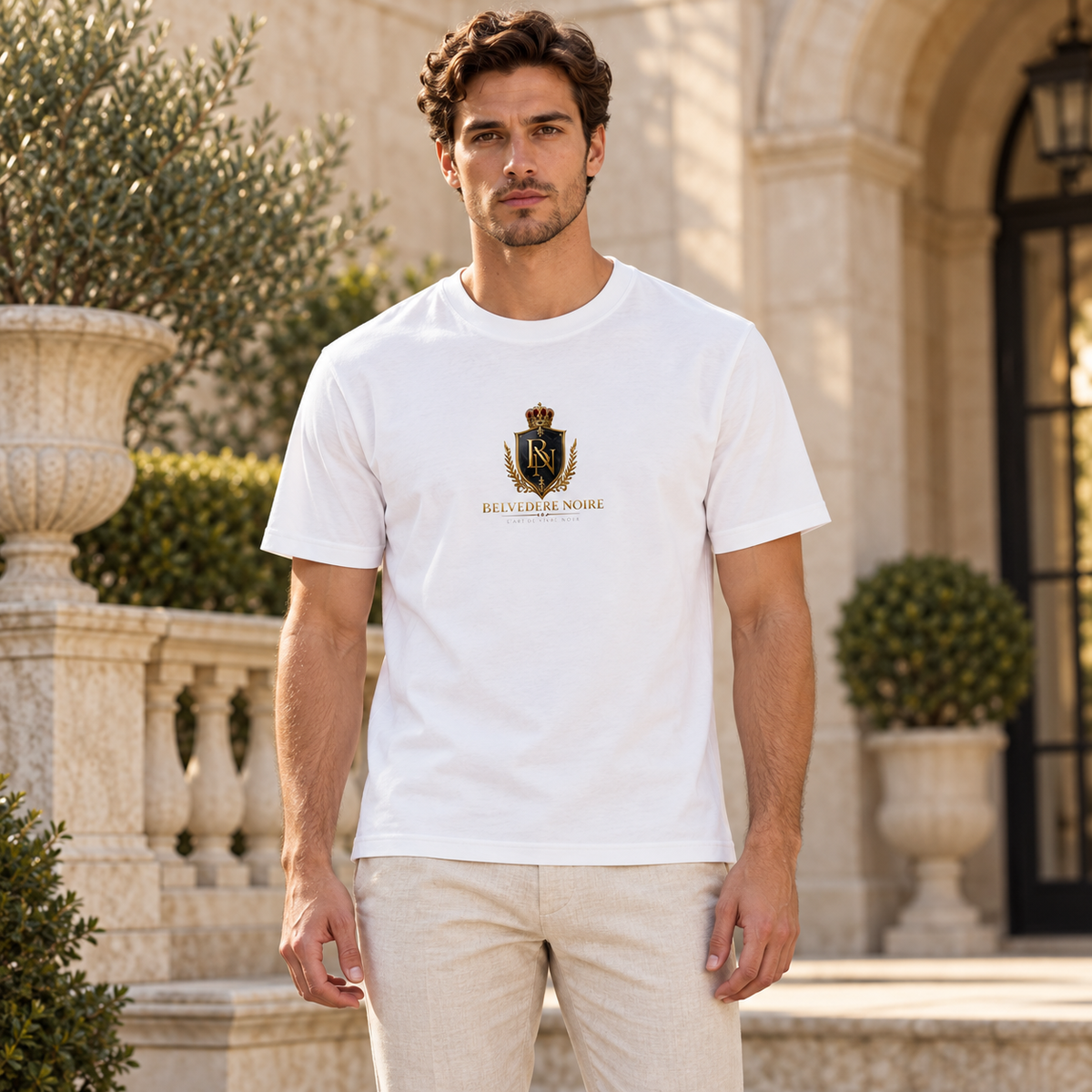 BELVEDERE NOIRE white crest tee, male model in limestone courtyard, AI styling mockup